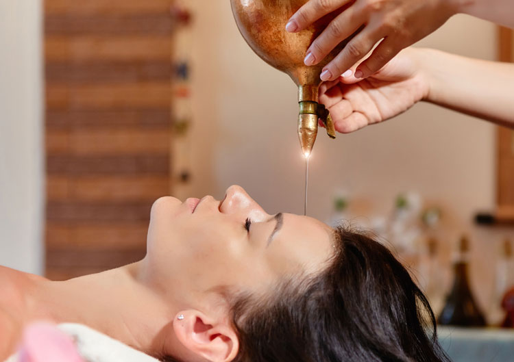 Frau erhält eine Shirodhara Massage